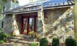 The entryway includes Tennessee Crab Orchard Stone and a standing seam roof.